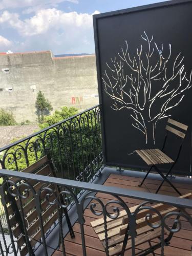 a balcony with a tree stenciled on the wall at Casas do Jardim in Marco de Canavezes