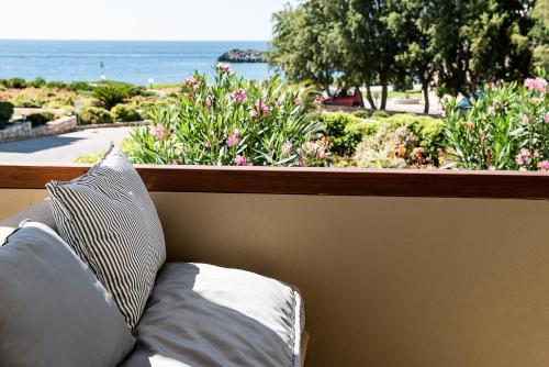 a couch in front of a window with a view of the ocean at Kavos Hotel & Suites in Stavros