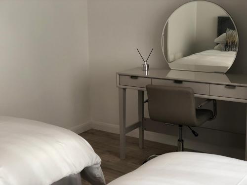 a bedroom with a desk with a mirror and a chair at The Villas holiday homes in Horden