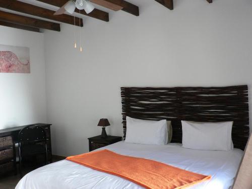 a bedroom with a bed with an orange blanket on it at Mountain View Eco Lodge Montagu in Montagu
