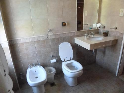 a bathroom with a toilet and a sink and a toilet istg at Las Balsas Hotel in Federación