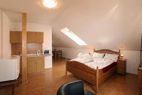 a large room with a bed and a kitchen at Penzion U Chodskeho Hradu in Domažlice
