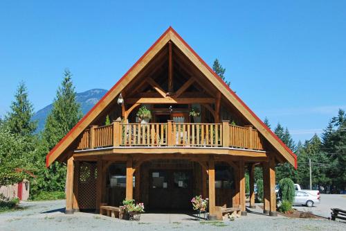 a large wooden cabin with a balcony on top at Owl Street Lodge in Hope