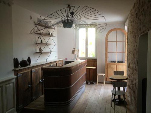 a kitchen with a bar with a table and a window at Hôtel de la Pinède in Juan-les-Pins