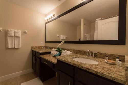 a bathroom with two sinks and a mirror at The Fountains Resort Orlando at ChampionsGate in Kissimmee