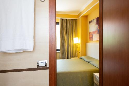 a hotel room with a bed and a door to a bedroom at Cervara Park Hotel in Rome