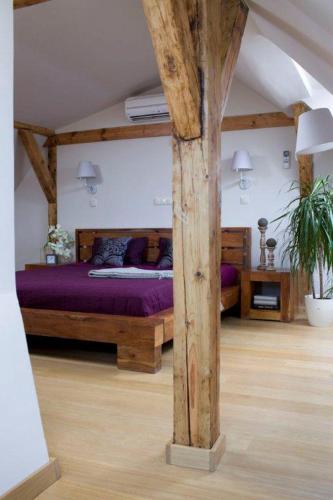 a bedroom with a large bed with purple sheets at Apartament Rynkowy in Kazimierz Dolny