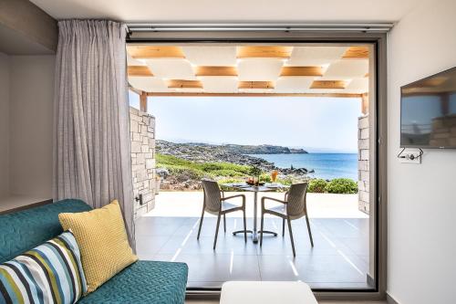 a dining room with a table and a view of the ocean at Kavos Hotel & Suites in Stavros