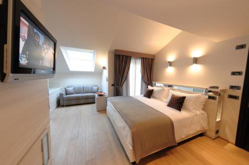 a hotel room with a bed and a flat screen tv at Hotel Ariston & Apartments in Varazze