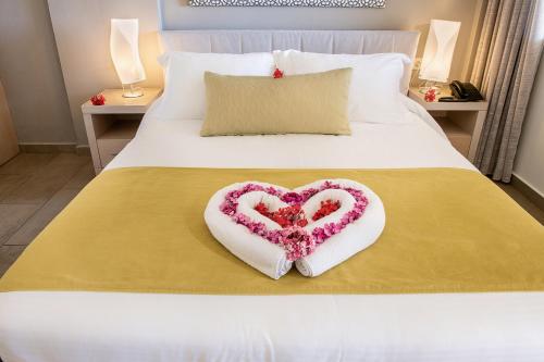 a heart shaped decoration on a bed in a bedroom at Kavos Hotel & Suites in Stavros