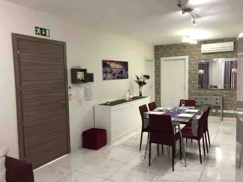 a kitchen and dining room with a table and chairs at Marsascala Sea View Apartment & Penthouse in Marsaskala