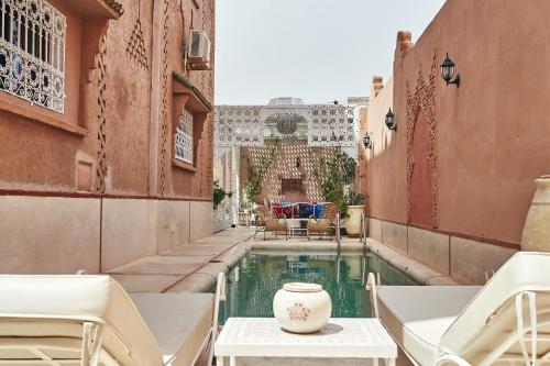 - une piscine dans une cour avec des chaises et une table dans l'établissement Riad Ouarzazate, à Ouarzazate