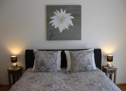 a bedroom with a bed with a flower painting on the wall at Chiemsee-Edelweiß Ferienwohnung in Prien am Chiemsee