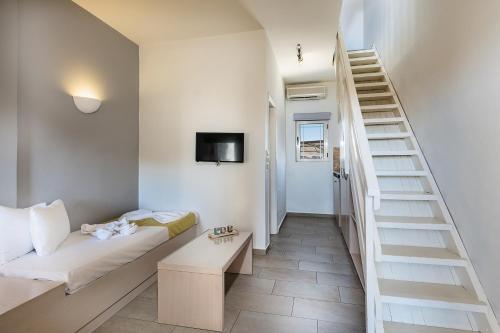 a living room with a couch and a staircase at Kavos Hotel & Suites in Stavros