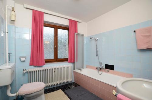 a bathroom with a tub and a toilet and a sink at Ferienwohnung Nussbaumer in Niedernsill
