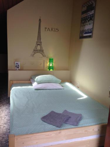 1 dormitorio con 1 cama con la torre Eiffel en la pared en Park Vendégház en Kecskemét