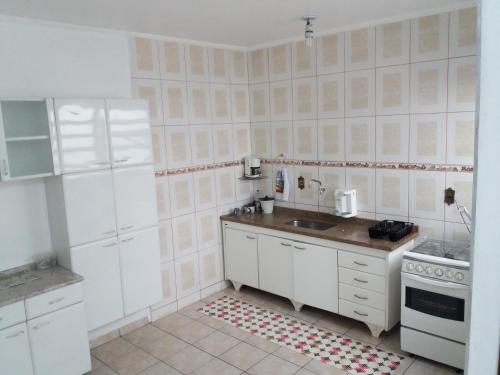uma cozinha branca com um lavatório e um fogão em Residencial Castelo Branco II em Campinas