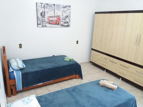 1 Schlafzimmer mit 2 Betten, einer Kommode und einem Bett sidx sidx in der Unterkunft Residencial Castelo Branco II in Campinas