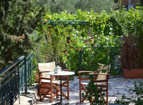 a patio with two chairs and a table in a garden at Althea Studios Lefkada in Agios Nikitas