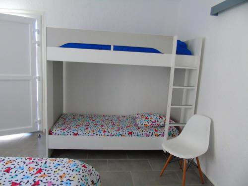 a bedroom with two bunk beds and a chair at Vllla Reva in Argelès-sur-Mer