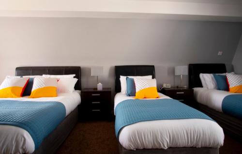 a bedroom with two beds with colorful pillows at Wilde Ballybunion in Ballybunion