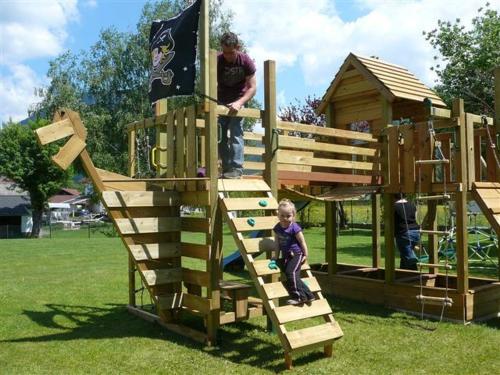 un homme debout au-dessus d'une structure de jeu en bois dans l'établissement Ferienwohnungen Kathrein, à Reutte