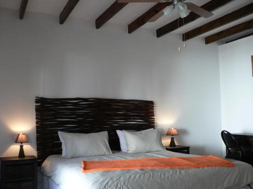 a bedroom with a bed with an orange blanket on it at Mountain View Eco Lodge Montagu in Montagu