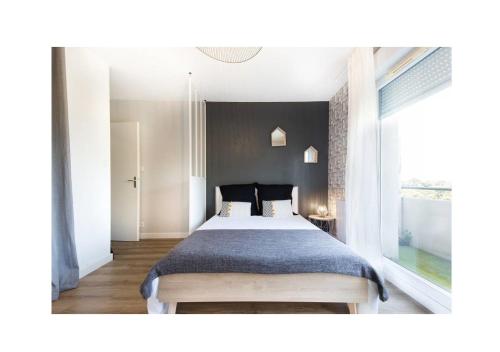 una camera con un grande letto e una finestra di Studio Diane Cugnaux Toulouse St Simon proche Thales, Airbus & Basso Cambo a Tolosa