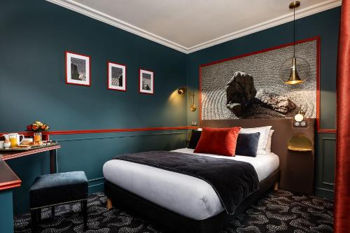 a room with a bed, a desk and a painting on the wall at Montparnasse Daguerre in Paris