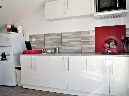 a kitchen with white cabinets and a white refrigerator at L'Oriflamme in Avignon