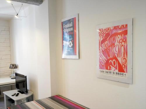 a room with a bed and a poster on the wall at L'Oriflamme in Avignon
