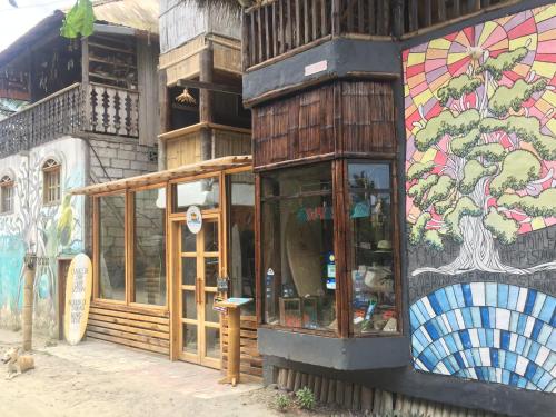 a store with a painting on the side of a building at La Facha Hostal Restaurant Surf in Mompiche