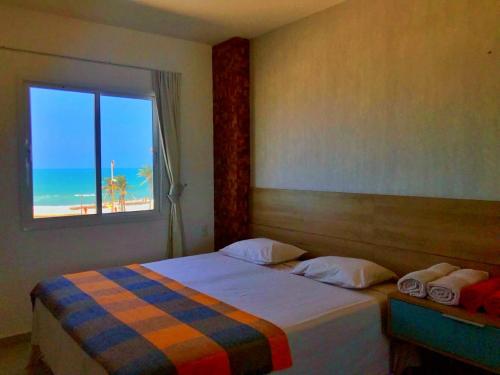 sypialnia z łóżkiem i widokiem na plażę w obiekcie AllMar Flats - Vg Fun - Frente mar w mieście Fortaleza