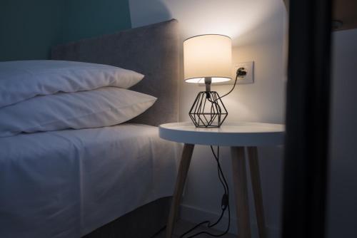 una lampada su un tavolino accanto a un letto di Chesscom Guesthouse a Budapest