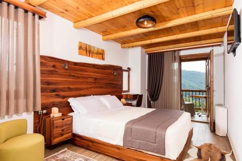 Redstone Luxury Villas في Theológos: غرفة نوم بسرير كبير وبلكونة