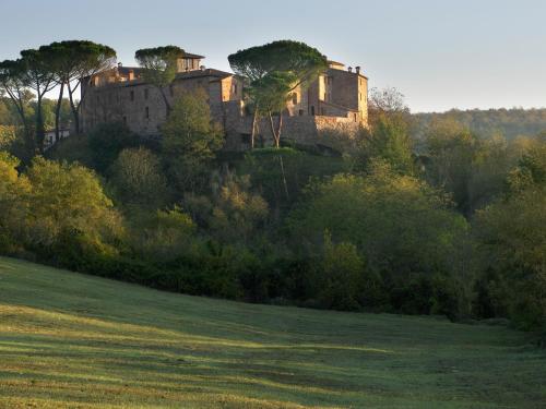 an old house on a hill in a field at Castel Monastero - The Leading Hotels of the World in Castelnuovo Berardenga