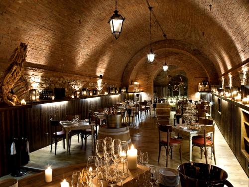 a dining room with tables and chairs and candles at Castel Monastero - The Leading Hotels of the World in Castelnuovo Berardenga
