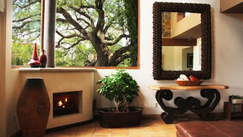 a living room with a fireplace and a mirror at Casa Toscana - Coronado 18 in San Miguel de Allende