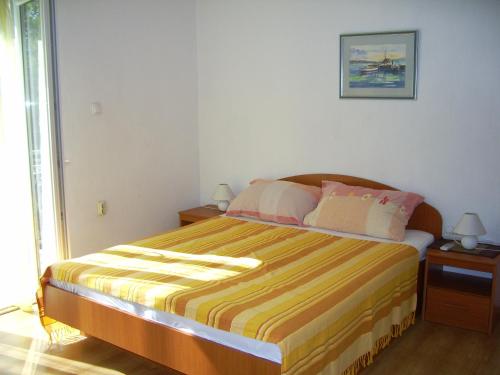 a bedroom with a large bed with a striped bedspread at Apartments Villa More in Makarska