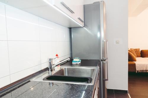 a kitchen with a sink in a room with a bed at Apartment Fila in Kochani