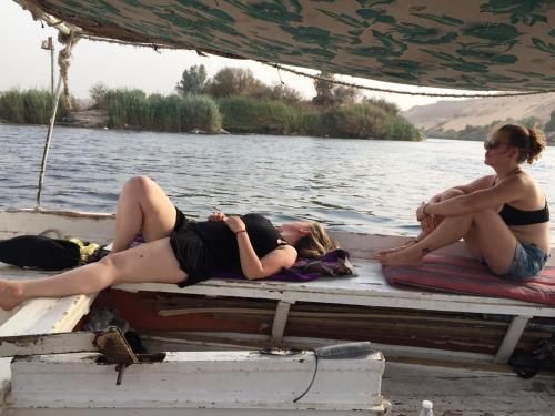 two women laying on the dock of a boat at david hostel in Aswan