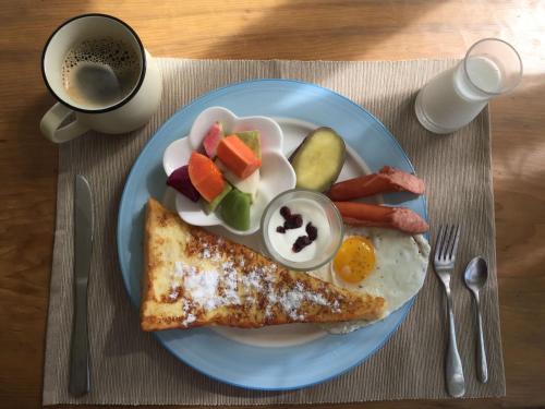 a blue plate of breakfast food with eggs bacon and vegetables at Lanshan House in Donghe