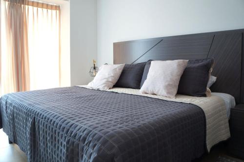 a bedroom with a large bed with a blue comforter at Metropolitan Suites in Guadalajara