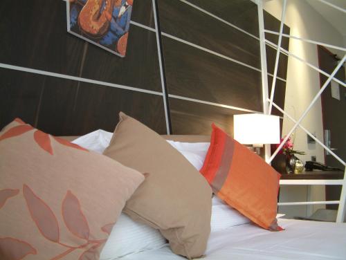 a bed with pillows and a headboard at Hotel Villa d'Elsa in Juan-les-Pins
