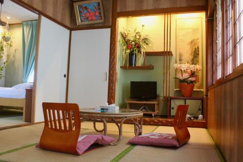 a living room with a table and two chairs at Shirahama Hotel in Nago