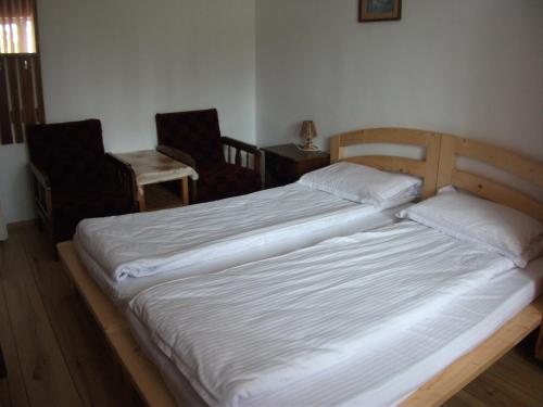 two twin beds in a room with two chairs at Vila Sport Borsec in Borsec