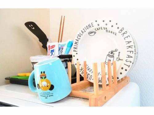 a wooden clock and a mug on a counter at Private House Sora / Vacation STAY 1122 in Sakai