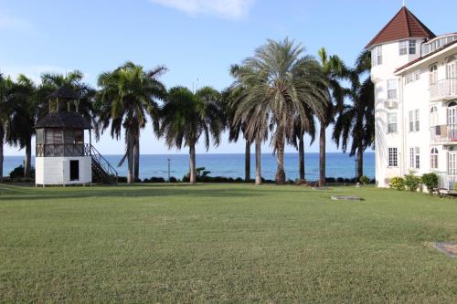 a building with palm trees and the ocean in the background at Seacastles by the beach/pool in Montego Bay