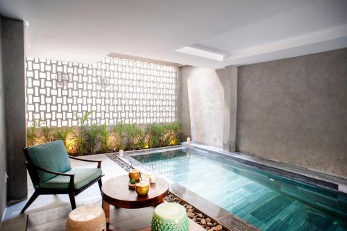 une chambre d'hôtel avec une piscine, une chaise et une table dans l'établissement Sen Boutique Villa Apartment, à Đà Nẵng