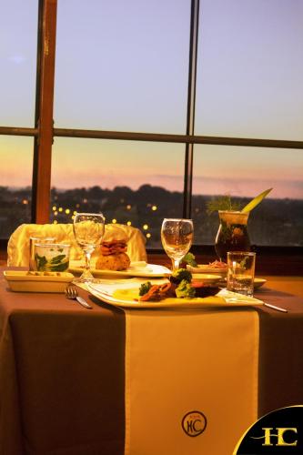 a table with a plate of food and wine glasses at Hotel Centenario in Puerto Maldonado